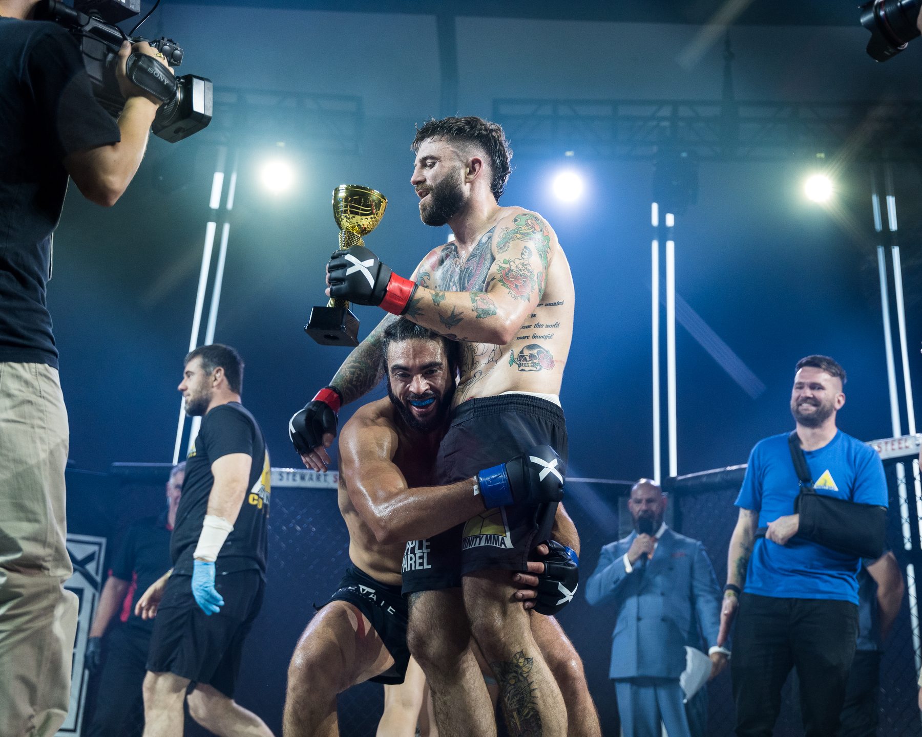 Fighter celebrating a win with a trophy inside the cage